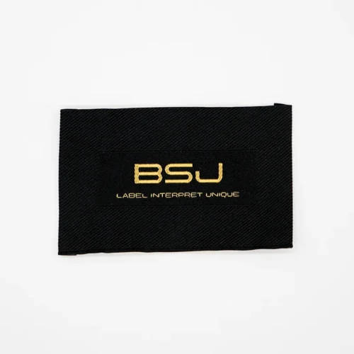 Étiquette tissée avec broderie dorée sur tissu noir pour sacs à dos