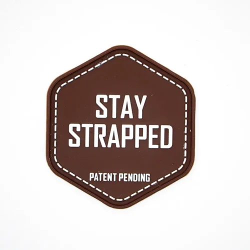 Parche de PVC con el logotipo hexagonal y el texto "Stay Strapped"